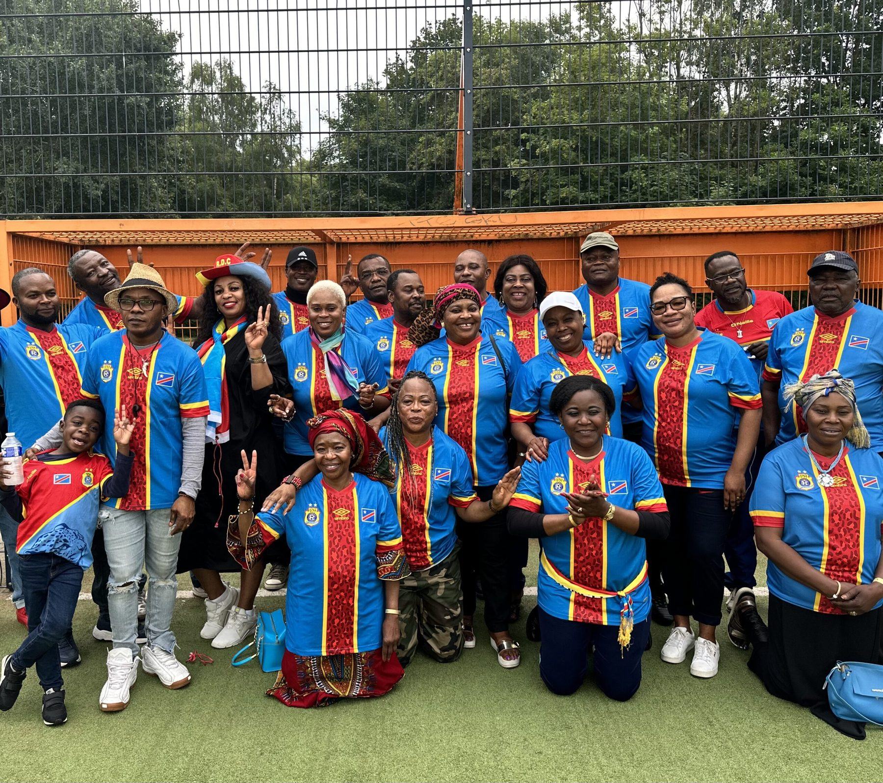Groep leden van BLB in blauw-geel-rode kleding, samen op de foto buiten.